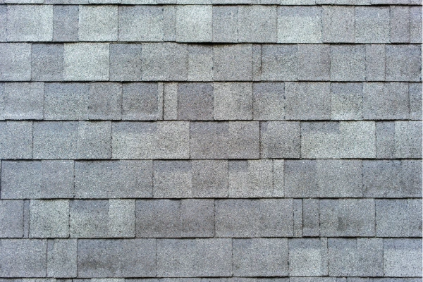 Close-up of asphalt shingles on a residential roof showing wear that may signal the need for roof repair.