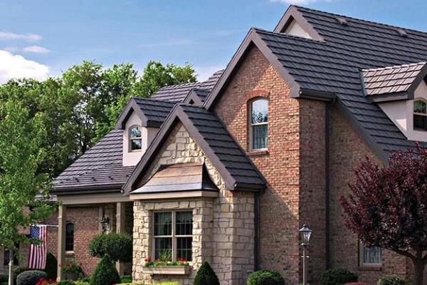 Brick home with a dark metal roof, showing how roofing material choice can affect curb appeal and home value.